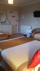 - une chambre avec un grand lit blanc et une commode dans l'établissement Broomfield House Bed and Breakfast, à Earlston