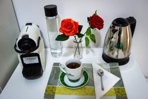 einen Tisch mit einer Tasse Kaffee und einer Vase Rosen in der Unterkunft B&B Saint Paul in Rom