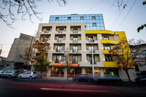 un edificio alto con coches estacionados frente a él en Hotel Duke Armeneasca - Ex Tempo, en Bucarest