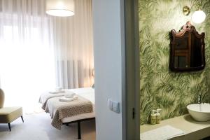 ein Schlafzimmer mit einem Bett und ein Badezimmer mit einem Waschbecken in der Unterkunft Santo da Casa / Sc apartments in Porto + 145 Fotos