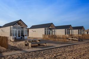 a row of houses on the beach with a picnic table at Surf en beach strandhuisjes in Katwijk