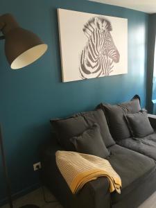 オンフルールにあるLa bonbonnière de Sofiのシマウマの写真を飾ったソファ付きのリビングルーム +1枚の写真