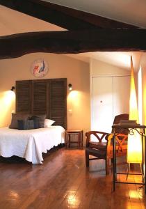um quarto com uma cama e uma cadeira num quarto em Pivoine et Cerise em Saint-Romain-de-Popey