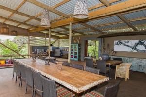 ein Esszimmer mit einem Holztisch und Stühlen in der Unterkunft Zululand Lodge in Hluhluwe