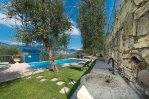 a stone wall with a sink in a yard at Agricampeggio Relax (Campsite) in Brenzone sul Garda