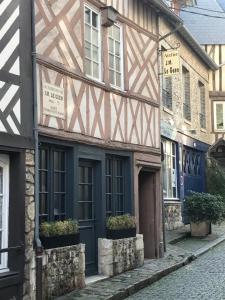 un edificio con una puerta azul en una calle en La bonbonnière de Sofi en Honfleur