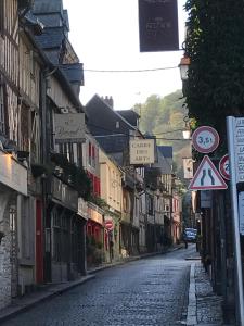 una calle vacía en una ciudad con carteles en los edificios en La bonbonnière de Sofi en Honfleur