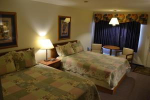 a hotel room with two beds and a table at Ranchmen Motel in Medicine Hat