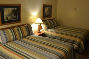 two beds sitting next to each other in a hotel room at Ranchmen Motel in Medicine Hat