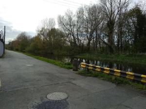 a yellow and black rail next to a river at Small Town House, Barrow Lane, Bagenalstown, Carlow in Bagenalstown