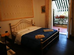 una camera da letto con un letto con una coperta blu e una finestra di B&B BARBERA a Firenze