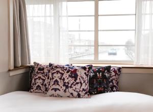 - un lit avec deux oreillers devant une fenêtre dans l'établissement SWEETS - Kinkerbrug, à Amsterdam
