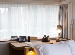 1 dormitorio con cama, escritorio y ventana en SWEETS - Kinkerbrug, en Ámsterdam