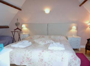 a bedroom with a bed with two towels on it at Le Mas de Gramat in Payrac