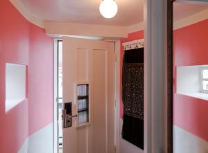 un pasillo con paredes rosas y una puerta con ventana en SWEETS - Kinkerbrug, en Ámsterdam