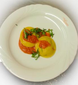 a white plate with a dish of food on it at Albergo Larese in Auronzo di Cadore