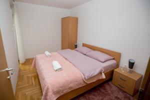 een slaapkamer met een bed met een telefoon erop bij Apartman G&A in Trebinje