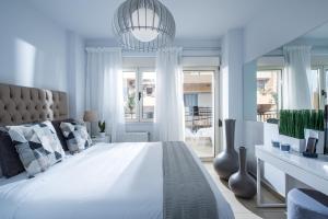 um quarto branco com uma cama grande e uma janela em Chanion One Suites by Good Life em Iráclio