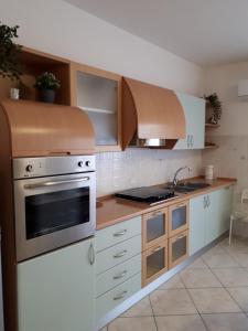 a kitchen with white cabinets and stainless steel appliances at La Conchiglia in Porto SantʼElpidio
