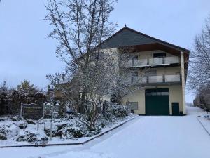 ein Gebäude mit Schnee auf dem Boden davor in der Unterkunft Ferienappartements Bernhart in Stadecken-Elsheim