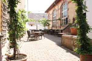 eine Außenterrasse mit Tischen, Stühlen und Pflanzen in der Unterkunft Gasthaus zum Lamm in Ettenheim