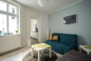 a living room with a blue couch and a table at Dream Team Pomorska in Bydgoszcz