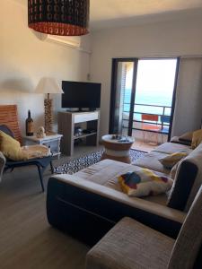 a living room with a large couch and a television at ColinaSol Vale Centeanes Appartement vue mer in Carvoeiro