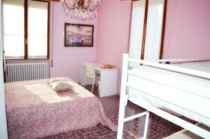 a bedroom with pink walls and a bed and a chandelier at The Swan B&B in Manerba del Garda