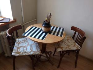 a small table with two chairs and a vase on it at Apartment Stepana Bandery Street in Rivne