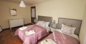 twee bedden in een kamer met roze lakens bij Casarão Paraíso in Perafita
