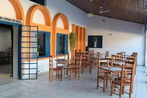 a row of tables and chairs in a restaurant at Pousada do Marcão in Ubatuba