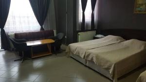 a hotel room with a bed and a desk and a window at Guest House Chinar 08 in Kirkovo