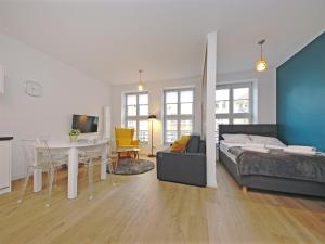 a living room with a bed and a dining room at Old Town by Apartmore in Gdańsk