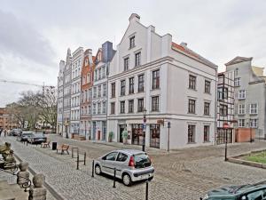 a car parked on a street in front of buildings at Old Town by Apartmore in Gdańsk