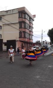 a group of people walking down a street with boats at HOSTAL LESLY SALOME in Tulcán