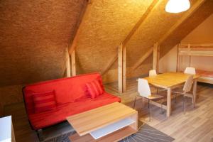 a living room with a red couch and a table at JEKAUPI in Pape