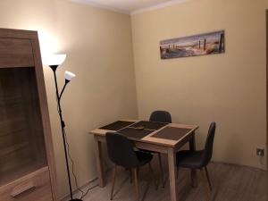 um quarto com uma mesa com cadeiras e um candeeiro em Apartament na Zielonej parter em Kędzierzyn-Koźle