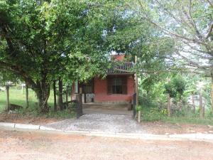 Chalézinho - Massaguaçu في كاراغواتاتوبا: بيت احمر صغير جالس تحت مجموعه اشجار