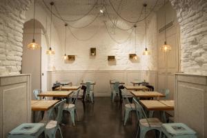 a restaurant with wooden tables and chairs and lights at Petit Palace Plaza del Carmen in Madrid