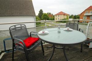 a table and two chairs on a balcony with a table and chairs at Zum Glückswinkel in Kühlungsborn