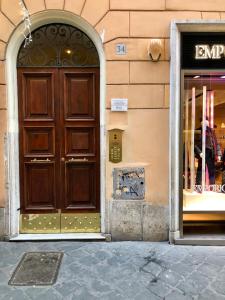 a large wooden door on the side of a building at Luxury Apartment Frattina 34 Anelli in Rome