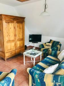 a living room with two couches and a tv at "Steuermannskammer" by Ferienhaus Strandgut in Born