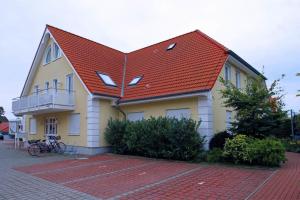 a house with a red roof on a brick street at Zum Glückswinkel in Kühlungsborn