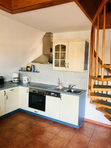 a kitchen with white cabinets and a sink at "Steuermannskammer" by Ferienhaus Strandgut in Born