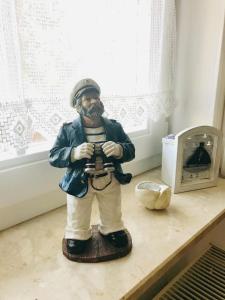a statue of a man holding a camera on a table at "Steuermannskammer" by Ferienhaus Strandgut in Born