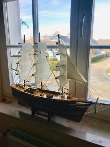 a wooden boat sitting on a window sill at "Steuermannskammer" by Ferienhaus Strandgut in Born