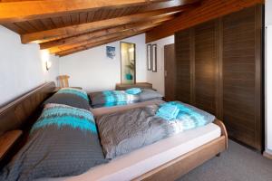 two beds in a room with wooden ceilings at Fortuna Dachgeschoss in Grächen
