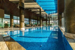 a large swimming pool with blue water in a building at Radisson Collection Hotel, Vadistanbul in Istanbul