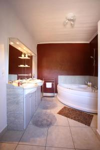 uma grande casa de banho com 2 lavatórios e uma banheira em Le Cayla em Leynhac