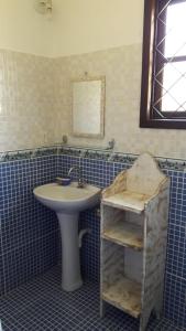 a bathroom with a sink and a mirror at Chalézinho - Massaguaçu in Caraguatatuba